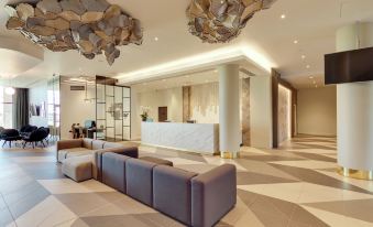 a modern hotel lobby with a large reception desk and multiple couches , creating a comfortable and inviting atmosphere at Hilton Garden Inn Doncaster Racecourse
