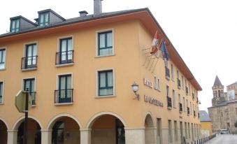 "a yellow building with a sign that says "" hotel el antioquia "" and several flags flying in front of it" at Hotel El Castillo