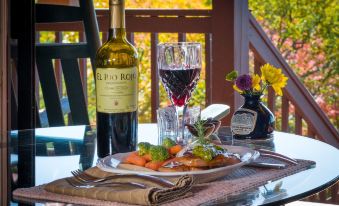 a dining table set with a wine glass , a bottle of wine , and a plate of food at North Fork Mountain Inn