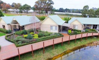 a bird 's eye view of a house with a wooden walkway and water in the background at Wild Cattle Creek Estate