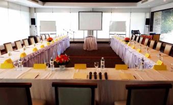 a large conference room with multiple tables set up for a meeting , each table has its own arrangement of items and flowers at Suwan Golf and Country Club
