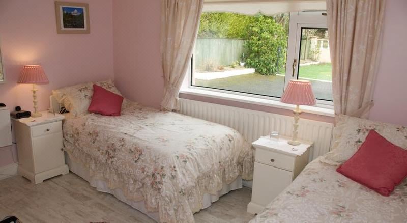 a pink bedroom with two twin beds , one on the left and one on the right side of the room at Lettermore