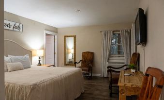 a well - lit bedroom with a bed , two chairs , and a desk , giving it a cozy and inviting atmosphere at Lone Star Lodge and Marina