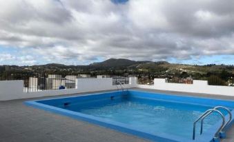 a large blue swimming pool with a view of mountains and hills in the background at Hotel Hermitage