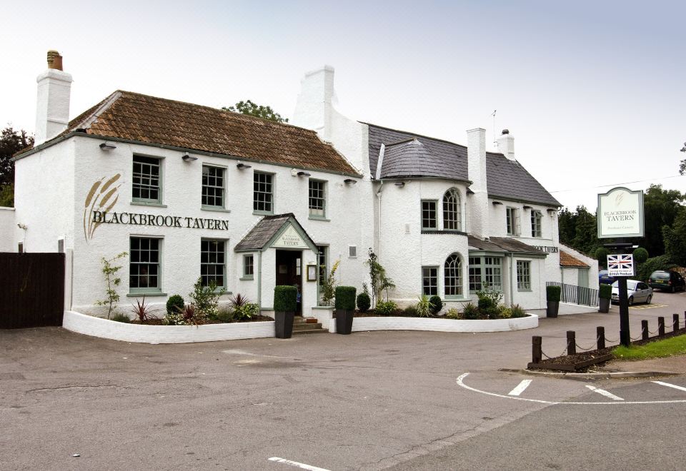 "a white building with a sign that reads "" lockbridge tavern "" is shown in front of a parking lot" at Taunton Ruishton (M5, J25)