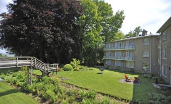 a well - maintained yard with a large green lawn , trees , and a building in the background at Fletcher Parkhotel Val Monte