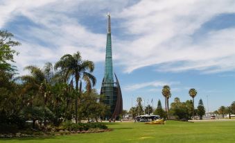 a tall green spire stands in the center of a lush green park with palm trees and other buildings at Durham Lodge Bed & Breakfast