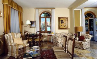 a cozy living room with a couch , chairs , and dining table in front of a window at Hotel Stella d'Italia