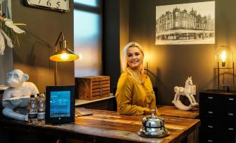 a woman sitting at a desk in a dimly lit room , smiling and posing for a picture at Mode Hotel Lytham