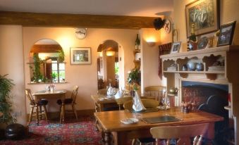 a dining room with wooden tables and chairs arranged for a group of people to enjoy a meal together at The Three Lions