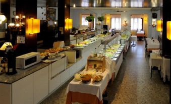 a long buffet table filled with a variety of food items , including sandwiches , fruits , and pastries at Royal Beach