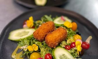 a dining table with two plates of food , one containing salad and the other filled with fried foods at Hotel Atlanta