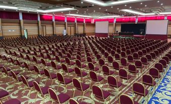 a large conference room with rows of chairs arranged in a semicircle , ready for an event at Grand Asrilia Hotel