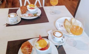 a table is set with plates of food , including a cake and a glass of orange juice at Villa Turistica de Bubion