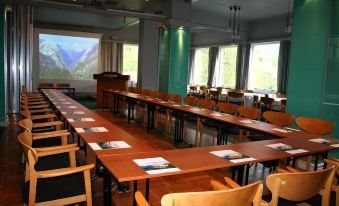 a conference room with wooden tables , chairs , and papers arranged for a meeting or presentation at Stalheim Hotel