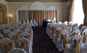 a wedding ceremony taking place in a room , with rows of chairs arranged for guests at Hardwicke Hall Manor Hotel