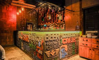 a bar with a green counter and colorful graffiti on the wall , creating a vibrant atmosphere at Hotel Paradise