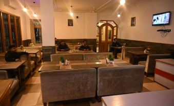 a group of people sitting at a table in a restaurant , enjoying their meals and conversation at Hotel Royal Palace