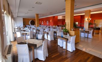 a large dining room with multiple tables and chairs , some of which are covered in white tablecloths at La Luna Hotel - All Inclusive