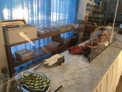 a restaurant counter with a variety of food items and drinks , including a pizza on a plate at Hotel Summery