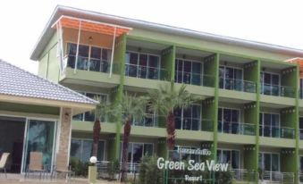 "a green and beige building with the words "" green sea view resort "" on top , surrounded by palm trees and grass" at Greenseaviewresort Bangsaphan