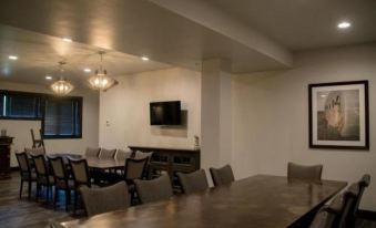 a large dining room with a long table and several chairs , as well as a television mounted on the wall at Okoboji Commons Hotel, Trademark Collection by Wyndham