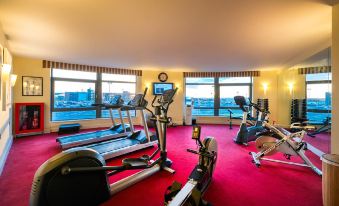 a well - equipped gym with various exercise equipment , such as treadmills , elliptical machines , and stationary bikes at Cork International Hotel