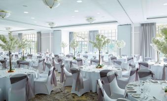 a large dining room with white tables and chairs set up for a formal event at Forest of Arden Country Club