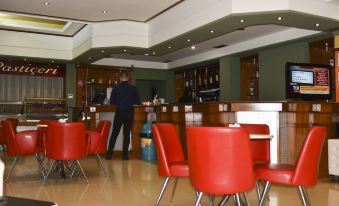 a man is standing in a restaurant , waiting for his food to be served to him at Hotel Liss