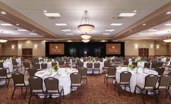 a large conference room with multiple round tables and chairs , surrounded by chairs and a chandelier at Great Wolf Lodge Grapevine