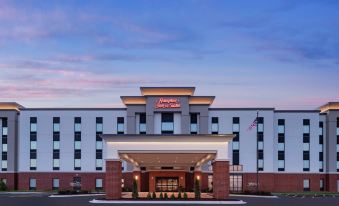 a large , modern hotel building with a red and white color scheme , located in a city at Hampton Inn & Suites Bridgeview Chicago