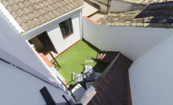 a bird 's eye view of a small white house with a green lawn and two sets of stairs leading to an outdoor area at La Torre