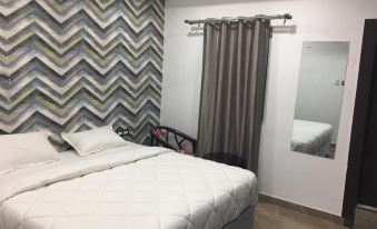 a modern bedroom with white walls , gray and white zigzag patterned wallpaper , and a bed with white bedding at Red Carpet