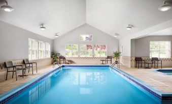 an indoor swimming pool with a blue and white color scheme , surrounded by chairs and tables at Residence Inn Harrisburg Carlisle