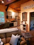 The Chalet is located in the woods of a gated property with a covered porch.