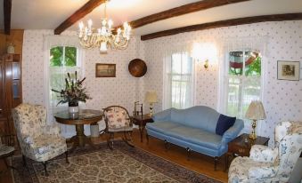 a cozy living room with a blue couch , a chair , and a rug on the floor at Christman's Windham House