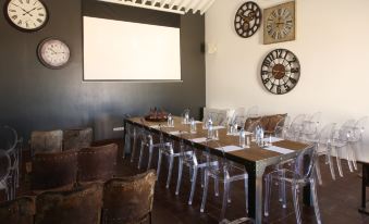 a long wooden table with multiple chairs and a projector screen in the background , set up for an event or meeting at Torre de Palma Wine Hotel, Montforte, a Member of Design Hotels