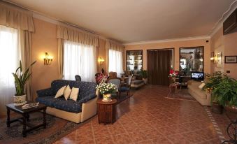 a spacious living room with various furniture , including a couch , chairs , and a dining table at Hotel Boston