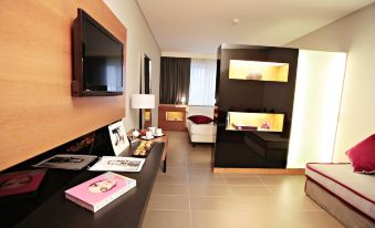 a modern hotel room with a flat screen tv , black table , and bed , along with some decorative items at Cosmopolitan Hotel