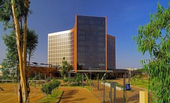 "a large building with the word "" sheraton "" prominently displayed on it , surrounded by greenery and trees" at Radisson Blu Hotel, Bamako