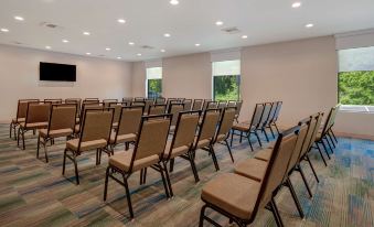 a large room with rows of chairs arranged in a semicircle , likely for a meeting or presentation at Home2 Suites by Hilton Marysville