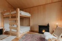 Tiny cabin amongst trees on a farm with alpacas