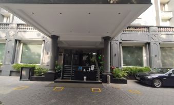 a modern building entrance with a glass door , surrounded by trees and bushes , and adorned with yellow lines on the ground at Park Inn by Radisson New Delhi Lajpat Nagar