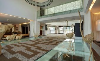 a large , open room with a glass floor and carpeted floor , featuring a sculpture on the wall at Devero Hotel  Spa, BW Signature Collection