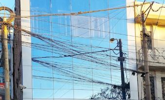 a tall building with a large glass window and many power lines hanging from it at Hotel Marbella