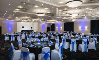 a large banquet hall filled with tables and chairs , all set up for an event at Mercure Telford Centre Hotel