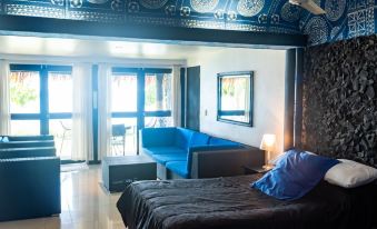 a modern bedroom with a blue couch , wooden floors , and large windows , decorated with an oriental - style ceiling design at Stevensons at Manase
