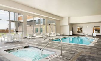 a large swimming pool with a hot tub and lounge chairs in a modern building at Homewood Suites by Hilton Salt Lake City Draper