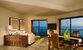 a living room with a large window overlooking the ocean , creating a serene and luxurious atmosphere at Las Palomas Beach & Golf Resort