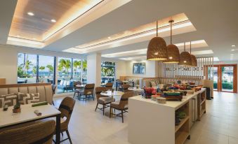 a restaurant with white walls and wooden ceiling , featuring several dining tables and chairs , as well as a bar area at Hyatt Regency Aruba Resort, Spa and Casino